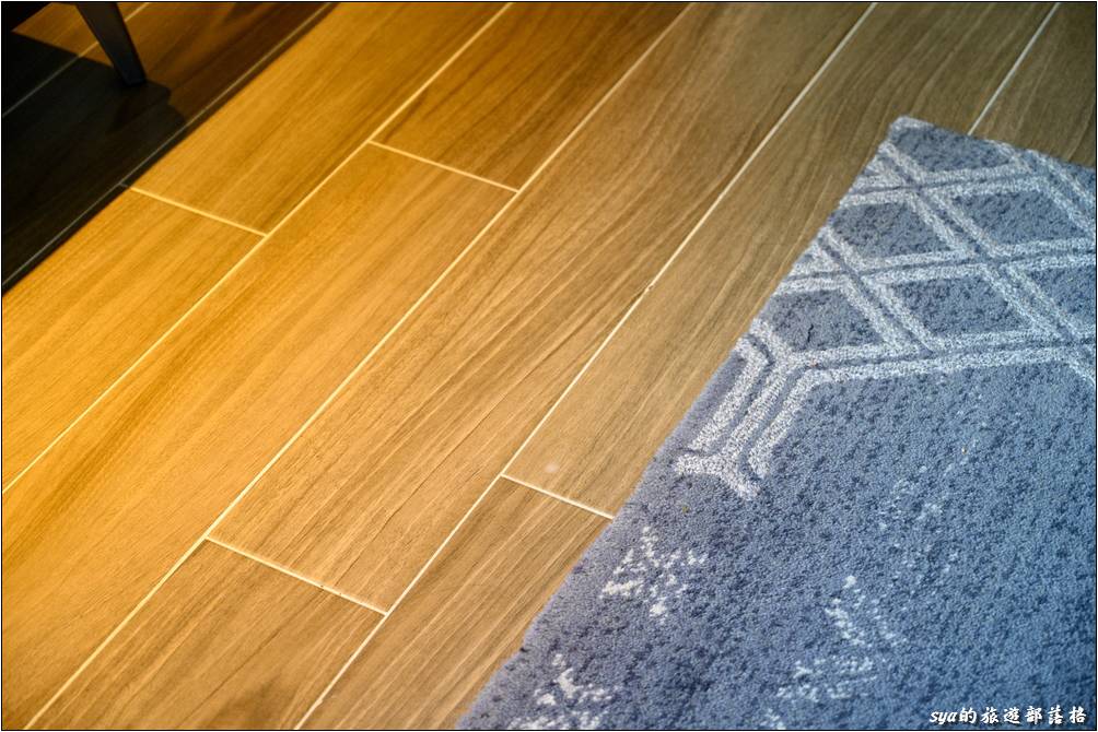 客房內是仿木紋的地板，床的周圍下床處則另外有地毯的鋪設，同時兼顧了清潔與下床時的舒適感。